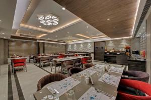 a restaurant with tables and chairs in a room at Hotel Suba Star Ahmedabad in Ahmedabad