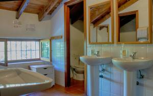 a bathroom with two sinks and a tub and a toilet at Riera d'Agres, relax, rural, grupos in Agres +32 photos
