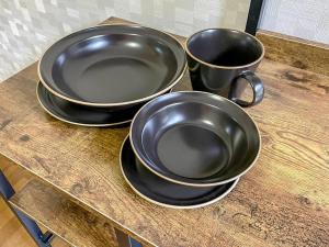 three black bowls and cups on a wooden counter at Villa Verde 那須 in Nasu