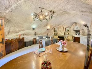 a dining room with a table in a cave style room at Cueva romántica - Jacuzzi in La Cabrera