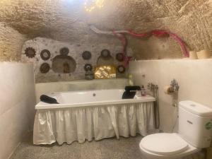 a bathroom with a bath tub and a toilet at Cueva romántica - Jacuzzi in La Cabrera