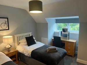a bedroom with a bed and a desk and a window at The Old Post House in Kyle of Lochalsh
