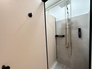 a shower with a glass door in a bathroom at RadZone Hostel in Singapore