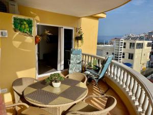 een patio met een tafel en stoelen op een balkon bij Relax and enjoy with a view of El Teide and sea in Puerto de Santiago