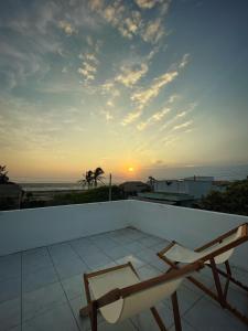 a view of the sunset from a balcony with a chair at QiHome Phú Quý in Cu Lao Thu +11 photos