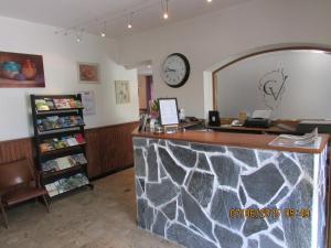 a store with a counter with a clock on the wall at Hotel Costa Verde in Moriani Plage