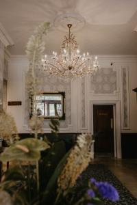 a living room with a chandelier and a table with flowers at The Orwell Hotel in Felixstowe