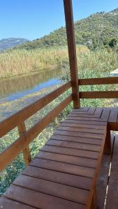 a wooden bridge over a river next to a fence at Lake house kayacık Resort in Dalaman