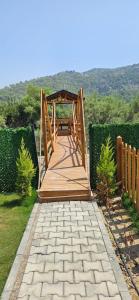 a wooden bridge over a walkway in a yard at Lake house kayacık Resort in Dalaman