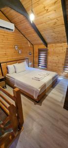 ein Schlafzimmer mit einem Bett in einem Holzzimmer in der Unterkunft Lake house kayacık Resort in Dalaman