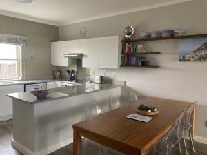 a kitchen with a wooden table and a counter top at Restore your Soul, Boulders Beach, Simonstown in Simonʼs Town