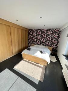 een slaapkamer met een bed met een bloemrijke muur bij Tehuizen Alness in Wetteren