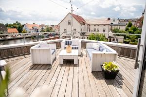 a deck with chairs and a table on a balcony at HafenHotel PommernYacht in Ueckermünde