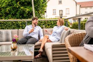 a man and a woman sitting on a patio at HafenHotel PommernYacht in Ueckermünde