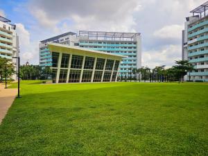 マニラにあるAcellyne's Suites at The Residences at Commonwealth by Centuryの前に緑の野原がある大きな建物 +33枚の写真