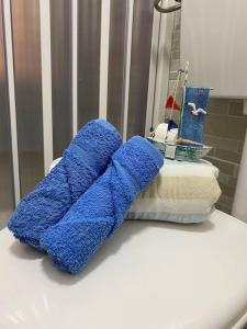 un par de toallas azules sentadas en la barra del baño en Casa Vacanza Giardini Naxos Taormina MIRANAXOS en Giardini Naxos