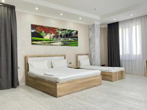 um quarto de hotel com duas camas num quarto em Dostar Inn em Shymkent