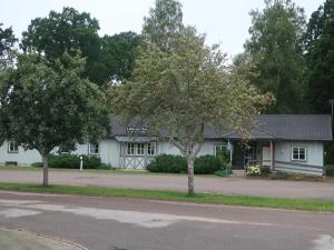 ein weißes Gebäude mit zwei Bäumen davor in der Unterkunft Hälsokällans Bed and Breakfast in Kyrkhult