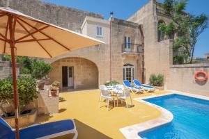 d'une terrasse avec une table et des chaises à côté de la piscine. dans l'établissement Dar ta' Betta Farmhouse with private pool, à L-Għarb