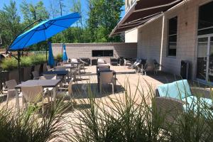 a patio with tables and chairs and an umbrella at Courtyard by Marriott Montreal West Island/Baie D’Urfe in Baie-dʼUrfé