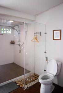 a bathroom with a toilet and a glass shower at LOYD Ratchaburi in Ban Tha Nat (4)