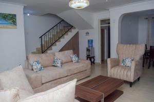 姆瓦帕的住宿－Happy Trails Home- Green Wood Estate Mtwapa，客厅配有沙发和两把椅子