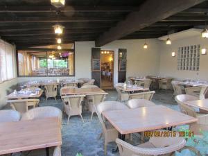 an empty restaurant with wooden tables and chairs at Hotel Costa Verde in Moriani Plage