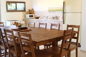 een keuken met een houten tafel met stoelen en een koelkast bij Beit Shapira in Kefar Shammay