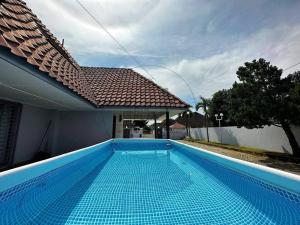 a blue swimming pool in front of a house at PD BlueBox Bungalow Sailor Theme (Up to 20 Pax) in Port Dickson