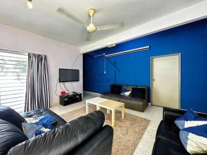 a living room with a couch and a blue wall at PD BlueBox Bungalow Sailor Theme (Up to 20 Pax) in Port Dickson