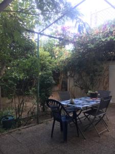 a table and chairs in a garden with a pergola at Agréable maison de ville au calme avec garage in Cannes