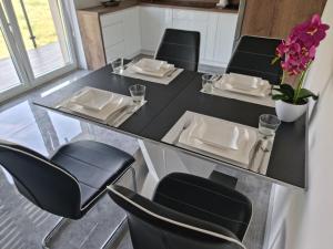 a dining room table with chairs and a black table and chairsktop at Apartment Kazimierza Wielkiego in Kętrzyn