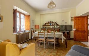 un soggiorno con tavolo, sedie e TV di Beautiful Home In Pieve San Lorenzo With Wifi a Pugliano