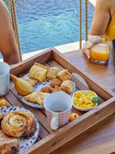 - un plateau de produits pour le petit-déjeuner sur une table à côté de l'eau dans l'établissement L'insolite MANAP'TIPIK, à Saint-Joseph