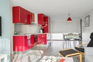 a kitchen with red cabinets and a table at Langeby Camping in Sandefjord