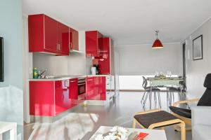 cocina con armarios rojos y mesa en Langeby Camping en Sandefjord