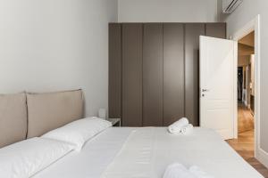 een slaapkamer met een wit bed en handdoeken bij Easylife - Lusso e comfort nel quartiere Brera in Milaan