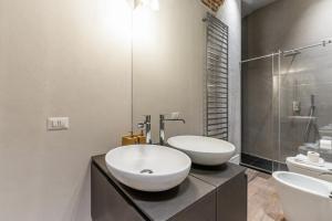 een badkamer met 2 wastafels en een glazen douche bij Easylife - Lusso e comfort nel quartiere Brera in Milaan