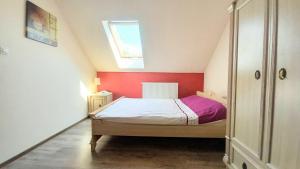 a small bedroom with a bed and a red wall at Ranczo na skarpie in Frampol