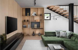 uma sala de estar com um sofá verde e uma televisão em Villa Pine Tree em Labin