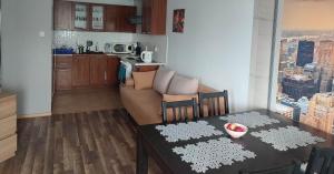 a kitchen and a living room with a table and a couch at Warsaw Apartment Iwona - all 45m2 - close to the centre in Warsaw