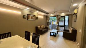 a living room with a table and a dining room at Abode Residency Safdarjung Enclave Near U S Embassy Delhi in New Delhi