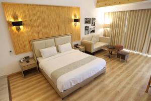 ein Schlafzimmer mit einem großen Bett und ein Wohnzimmer in der Unterkunft Kasauli Hills Resort in Kasauli