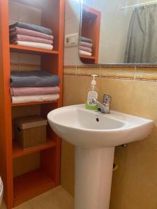 La salle de bains est pourvue d'un lavabo, d'un miroir et de serviettes. dans l'établissement primera linea playa rincon de la victoria, à Rincón de la Victoria
