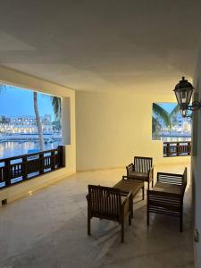 three benches in a room with a view of the water at Marina Flat Hawana in Salalah