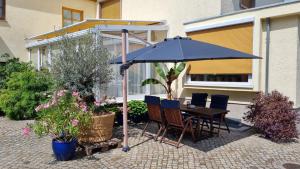 - une table et des chaises sous un parasol sur la terrasse dans l'établissement Ferienwohnung Kirsten, à Markranstädt