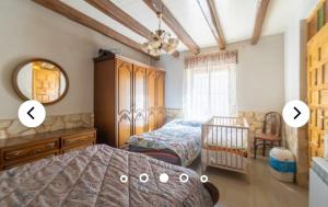a bedroom with a bed and a crib and a mirror at LA VILLA in Villarrín de Campos