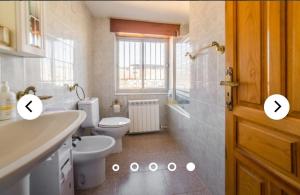 a bathroom with a toilet and a sink at LA VILLA in Villarrín de Campos