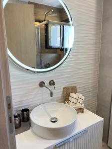 プレベザにあるComfort houseの白い洗面台と鏡のあるバスルーム