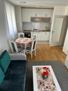 Il comprend un salon avec une table et une cuisine. dans l'établissement Luxury apartments - Otoka Sarajevo, à Sarajevo